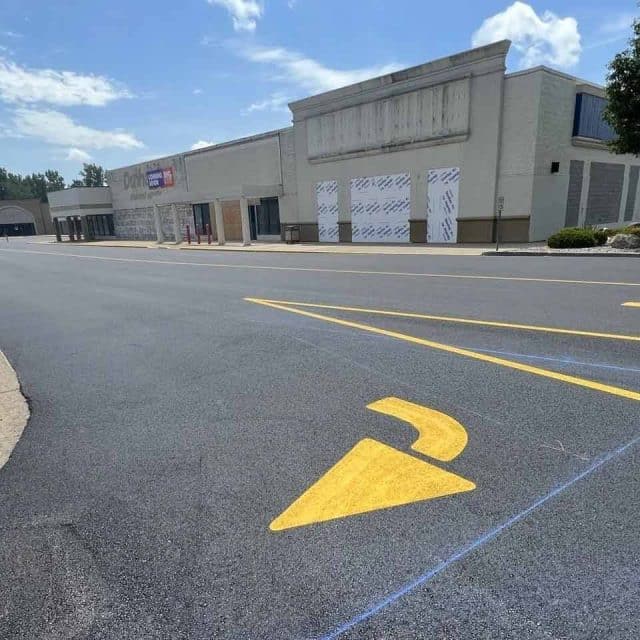 Empty storefronts in a strip mall with clear blue skies above.