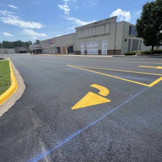 Empty parking lot with fresh markings and a no left turn sign.