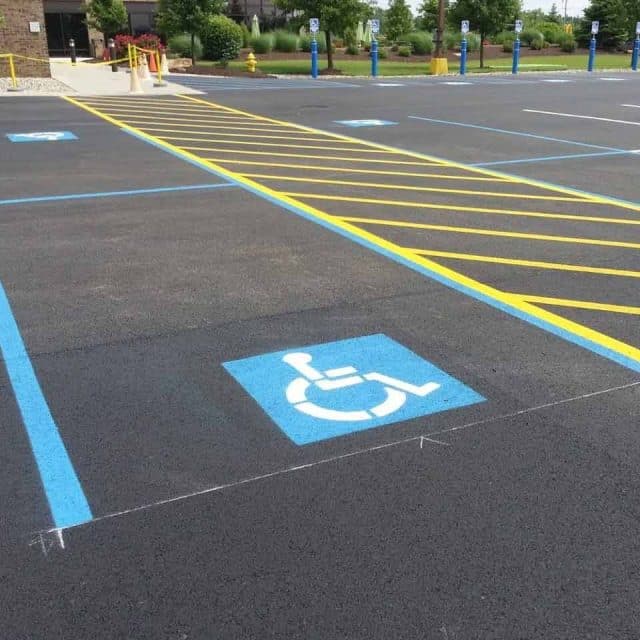 Empty parking lot with blue handicapped and yellow lined spaces.